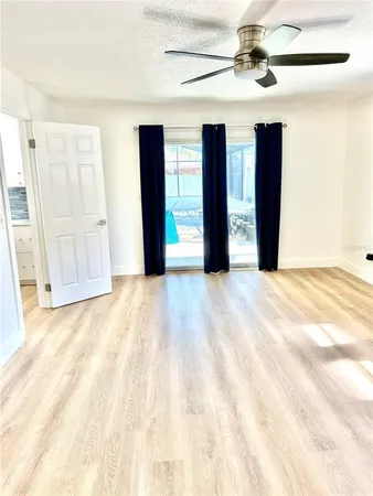 a view of an empty room with closet and a window