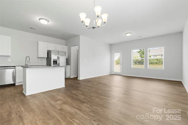 a view of a kitchen with window and wooden floor