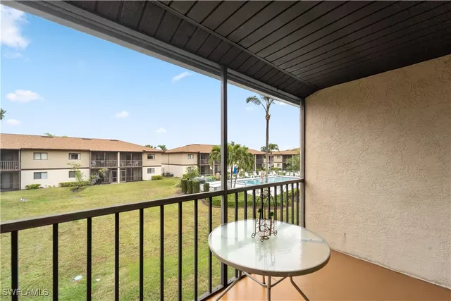 a view of a balcony with a table and chairs and wooden fence