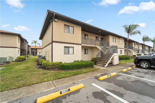 a white house with a yard and table and chairs