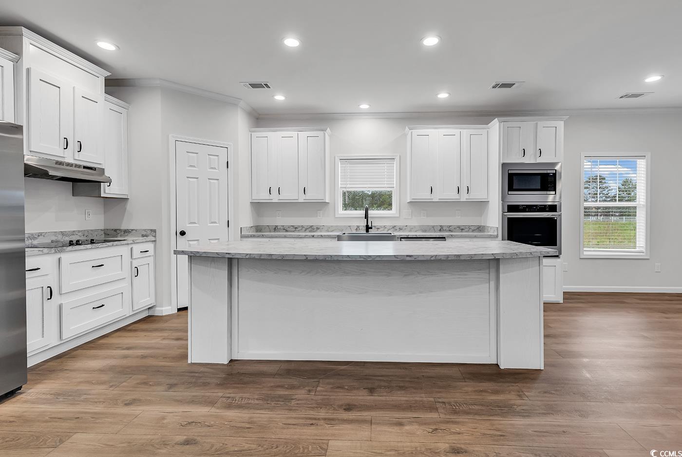1529 Bucksport Road Conway, SC 29527 - Photo 13 of 31 Kitchen featuring a center island, light countertops, white cabinetry, crown molding, and recessed lighting