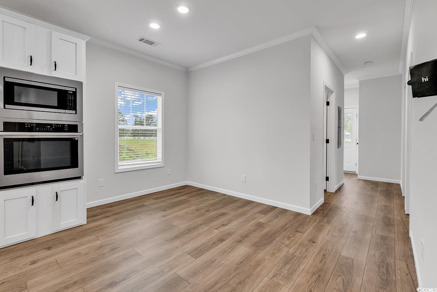1529 Bucksport Road Conway, SC 29527 - Photo 17 of 31 Kitchen featuring stainless steel appliances, crown molding, light wood-style flooring, white cabinetry, and recessed lighting