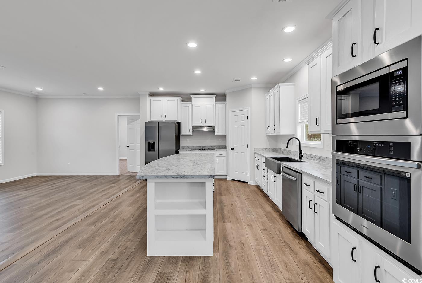 1529 Bucksport Road Conway, SC 29527 - Photo 8 of 31 Kitchen featuring ornamental molding, appliances with stainless steel finishes, open shelves, white cabinetry, and a kitchen island