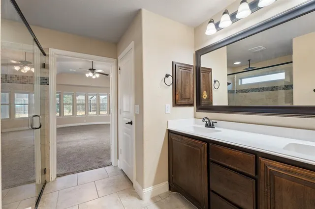 a bedroom with a large bed and a chandelier fan