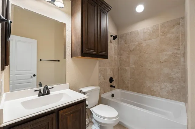 a spacious bedroom with a bed a couch and a chandelier fan