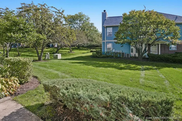 a view of a house with a big yard and large trees