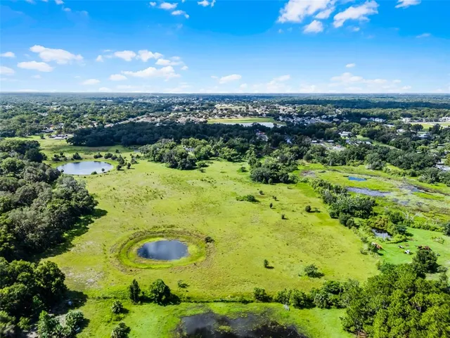 an aerial view of residential houses with yard and lake view
