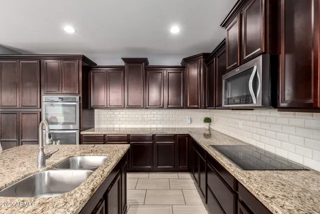 a kitchen with a sink stove top oven and refrigerator