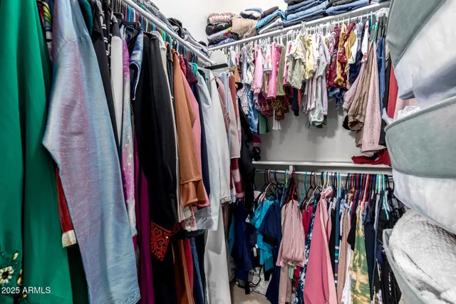 a view of walk in closet with clothes