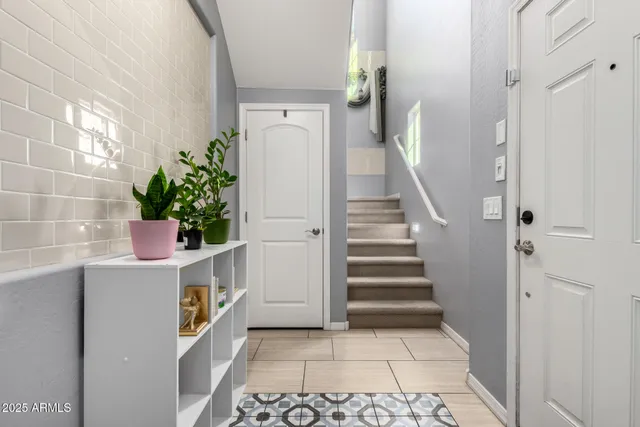 a view of a hallway with entryway and stairs