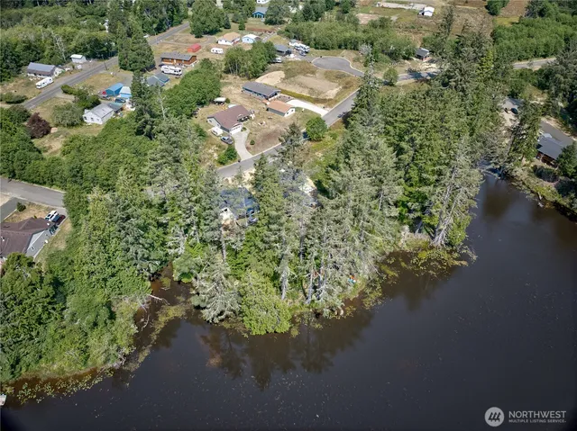 an aerial view of a house with a yard and lake view