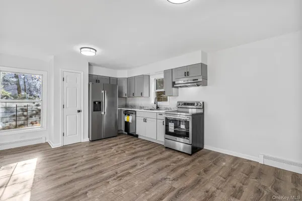 a kitchen with stainless steel appliances a stove top oven and a refrigerator