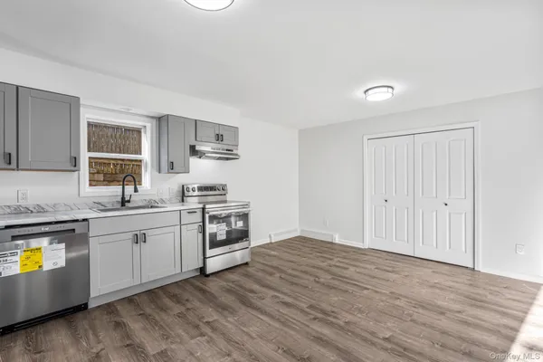a kitchen with a sink cabinets and wooden floor