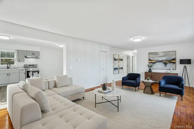 a living room with furniture and a view of kitchen