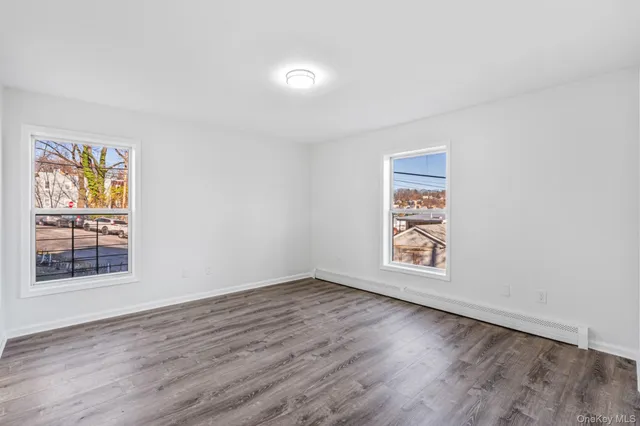 an empty room with wooden floor and window