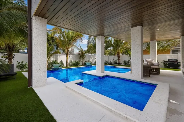 a view of a swimming pool with a lounge chairs in patio