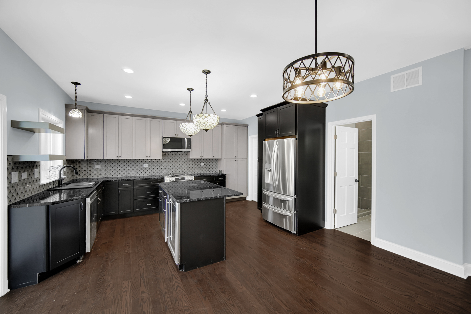 6532 West 112th Street Worth, IL 60482 - Photo 8 of 27 a kitchen with a chandelier stainless steel appliances kitchen island a stove and a wooden floors