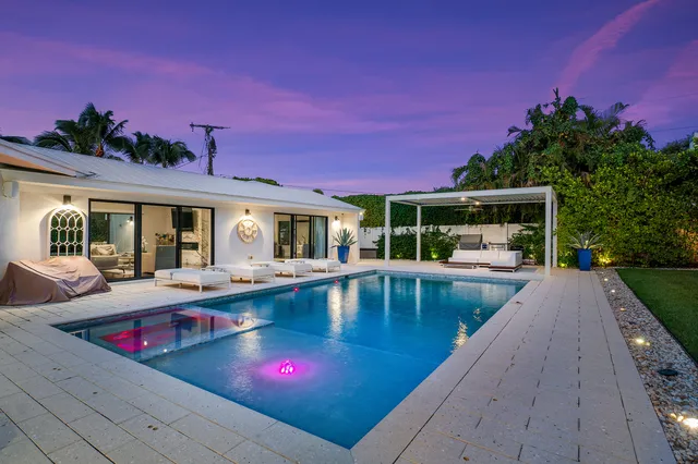 a living room with patio furniture and a potted plant