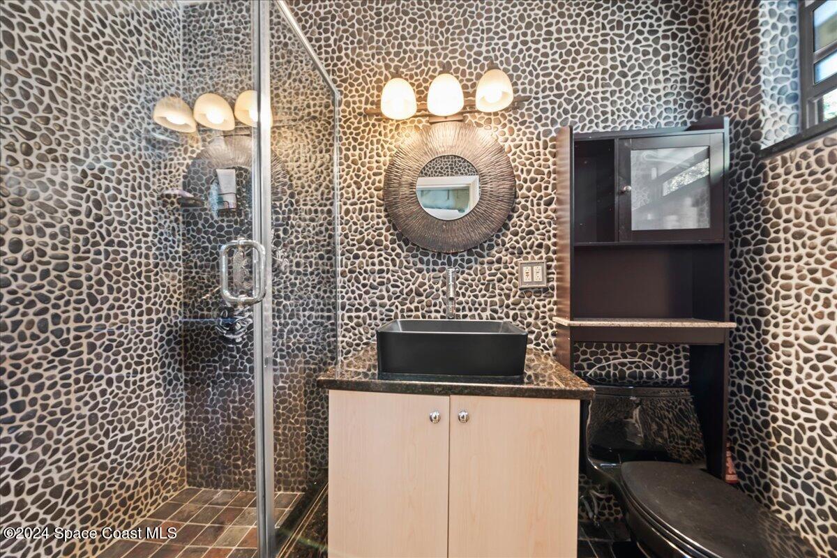 1509 Hedrick Drive Melbourne, FL 32901 - Photo 11 of 20 a bathroom with a toilet a sink and mirror