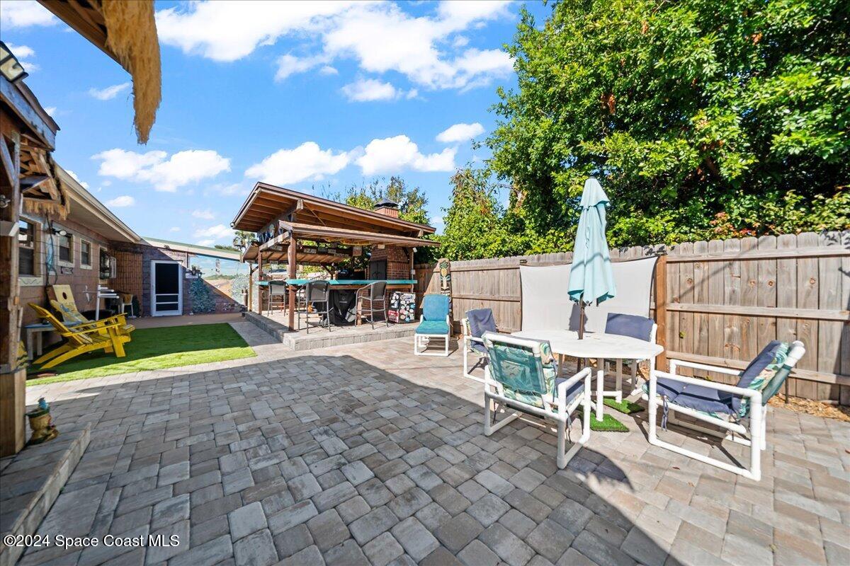 1509 Hedrick Drive Melbourne, FL 32901 - Photo 18 of 20 a view of a patio with table and chairs and floor to ceiling window