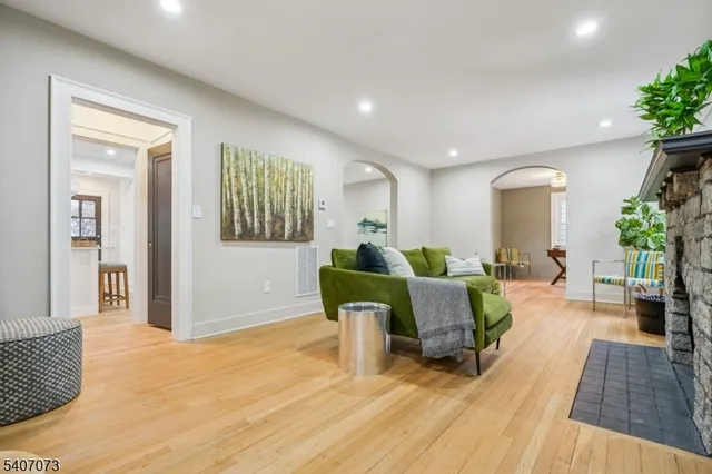 a kitchen with stainless steel appliances granite countertop a refrigerator a sink dishwasher a stove and a refrigerator with wooden floor