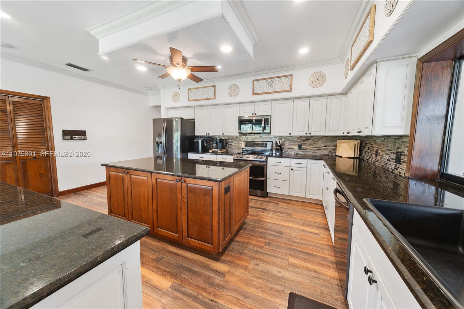 1872 Southeast Colony Way Jupiter, FL 33478 - Photo 26 of 26 a kitchen with stainless steel appliances granite countertop wooden cabinets sink and stove