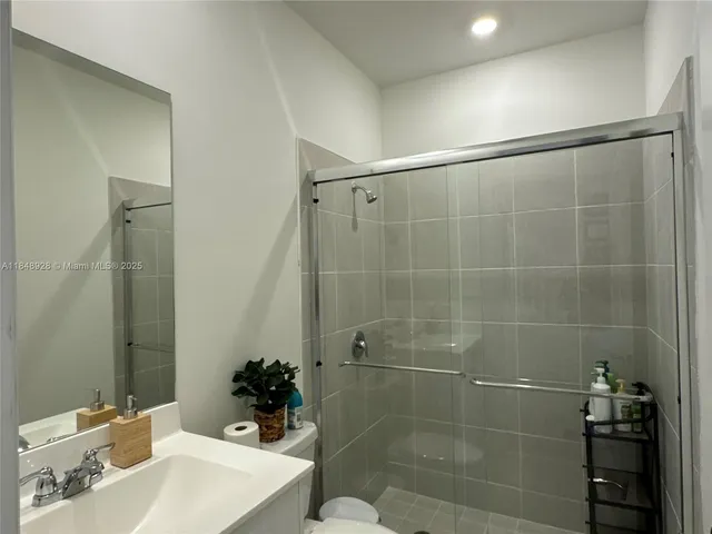 a bathroom with a sink mirror and shower