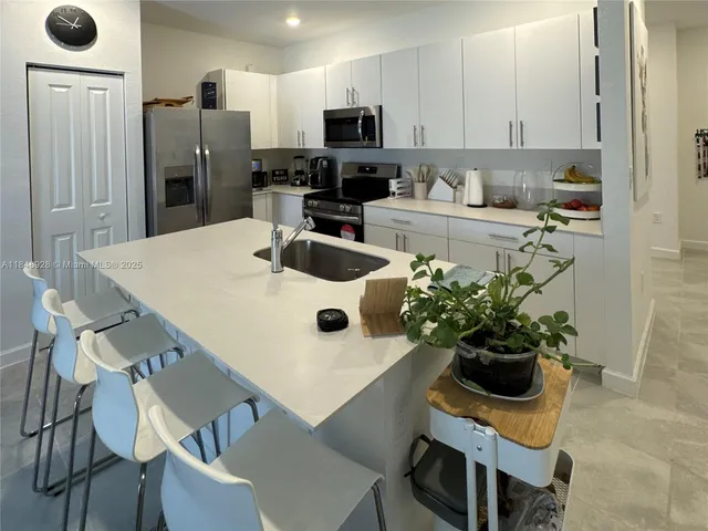 a kitchen with a white cabinets and chairs
