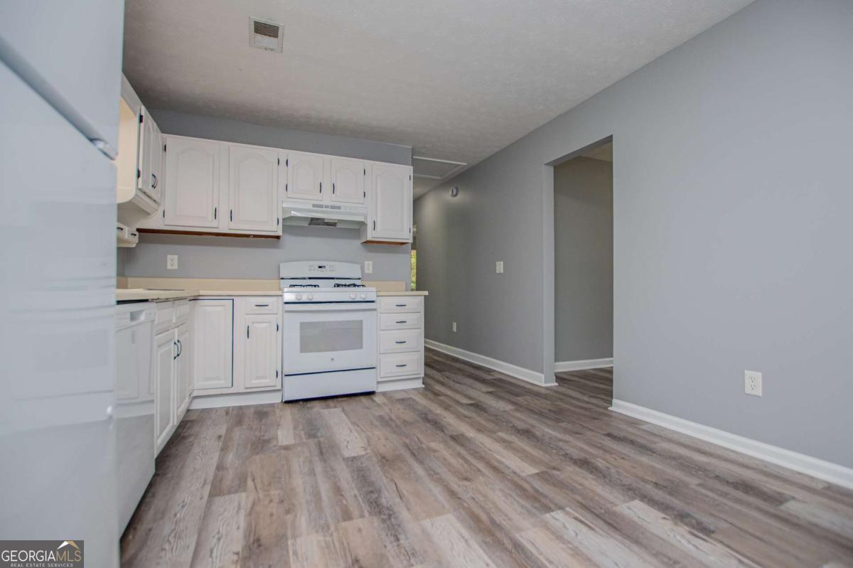 801 Bowdon Tyus Road Bowdon, GA 30108 - Photo 12 of 62 a kitchen with white cabinets and white appliances