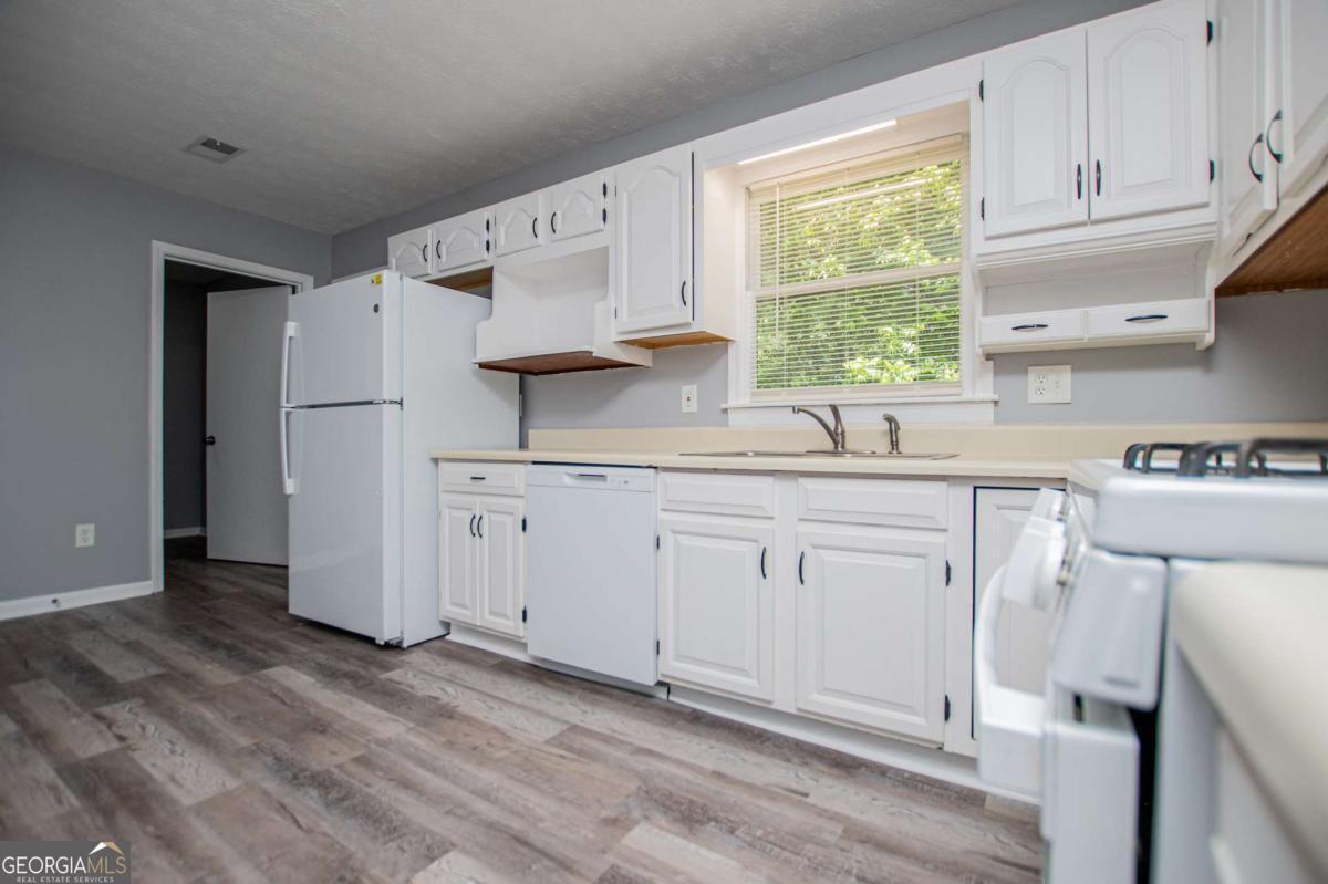 801 Bowdon Tyus Road Bowdon, GA 30108 - Photo 14 of 62 a kitchen with cabinets appliances a sink and a window
