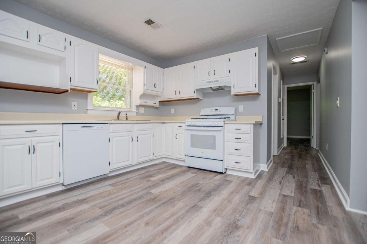 801 Bowdon Tyus Road Bowdon, GA 30108 - Photo 16 of 62 a large kitchen with cabinets and wooden floor