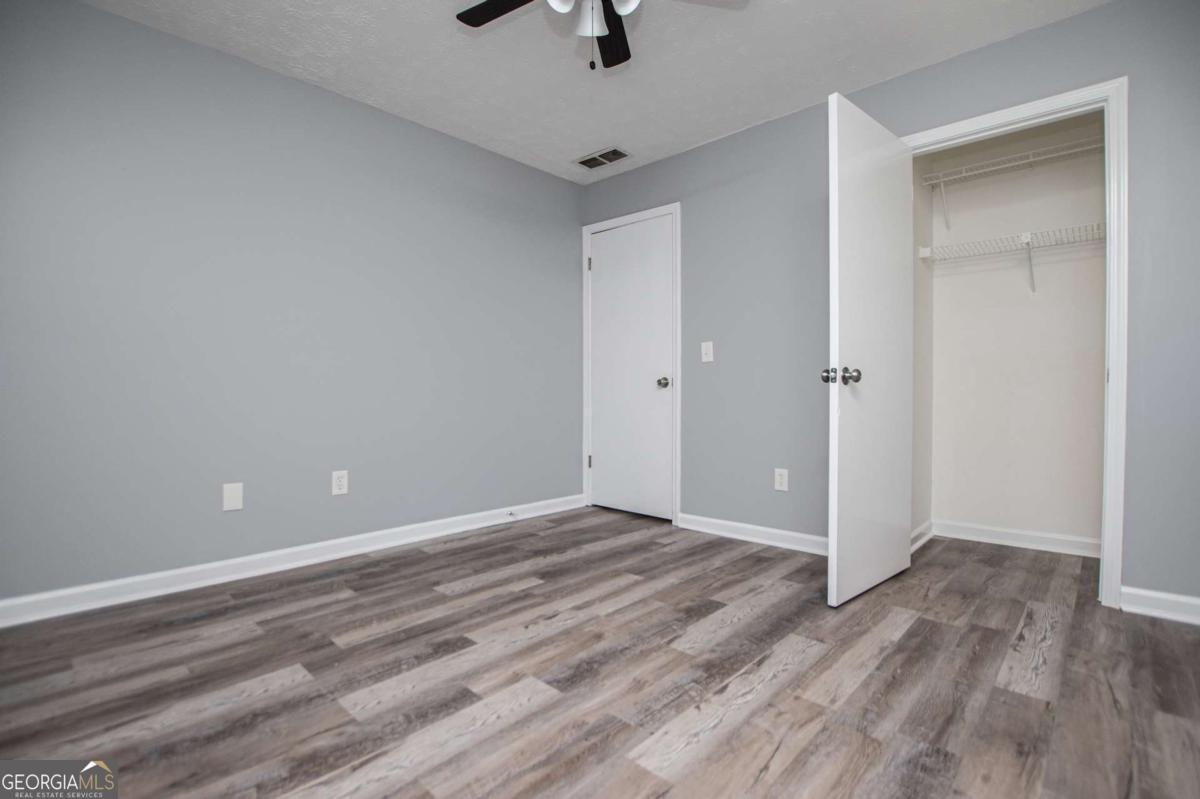 801 Bowdon Tyus Road Bowdon, GA 30108 - Photo 24 of 62 a view of an empty room with wooden floor and a ceiling fan