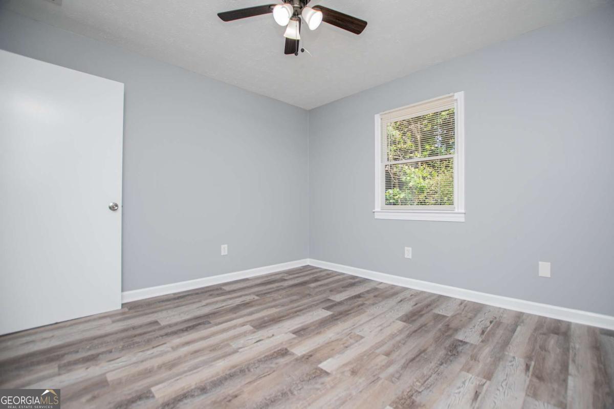 801 Bowdon Tyus Road Bowdon, GA 30108 - Photo 30 of 62 a view of an empty room with wooden floor and a window