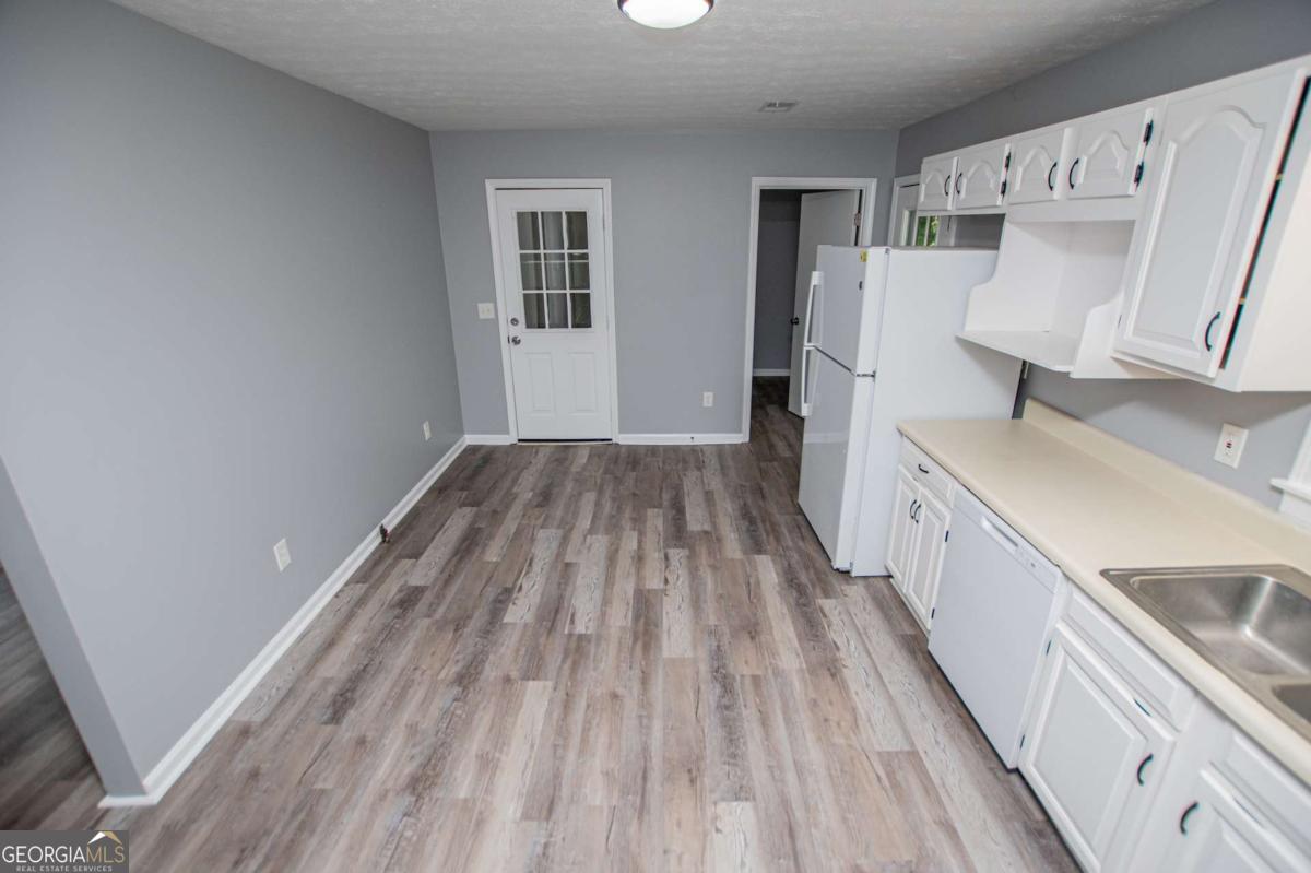 801 Bowdon Tyus Road Bowdon, GA 30108 - Photo 9 of 62 a view of a kitchen with wooden floor and electronic appliances