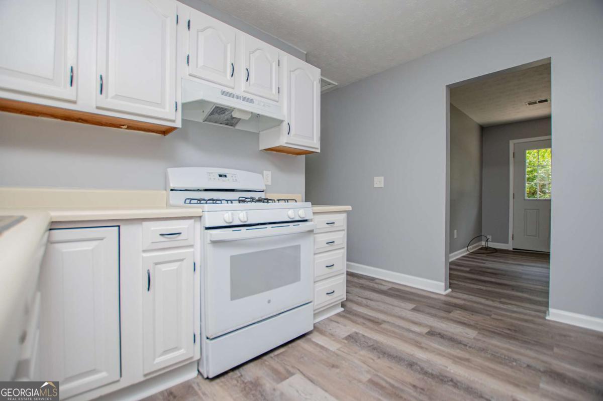 801 Bowdon Tyus Road Bowdon, GA 30108 - Photo 10 of 62 a kitchen with white cabinets and appliances