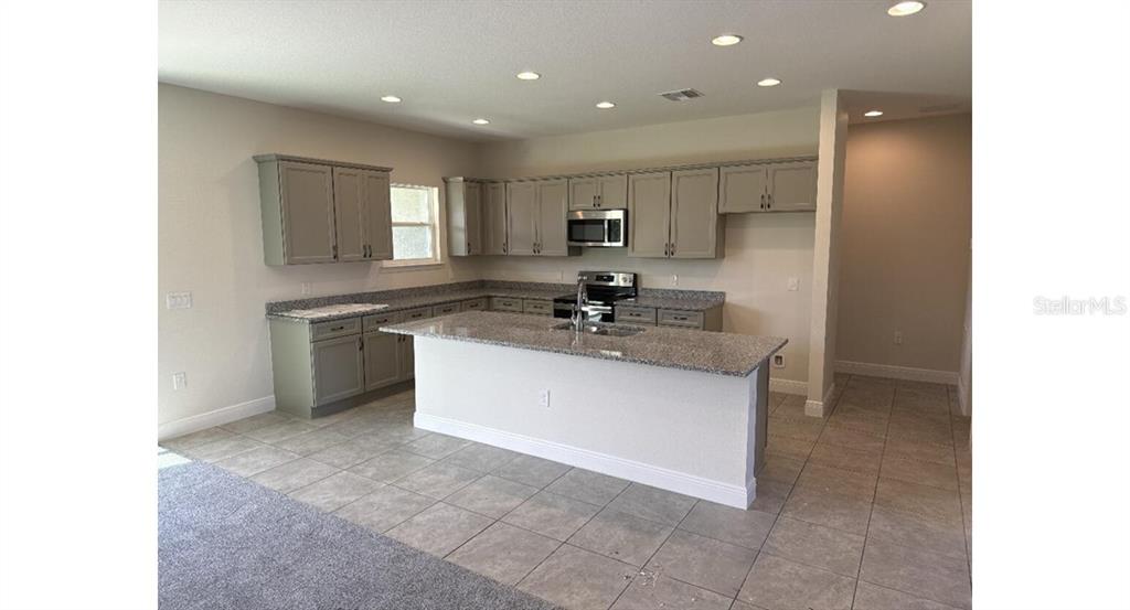 2573 Tulsa Avenue North Port, FL 34286 - Photo 2 of 11 a kitchen with kitchen island a sink stainless steel appliances and cabinets