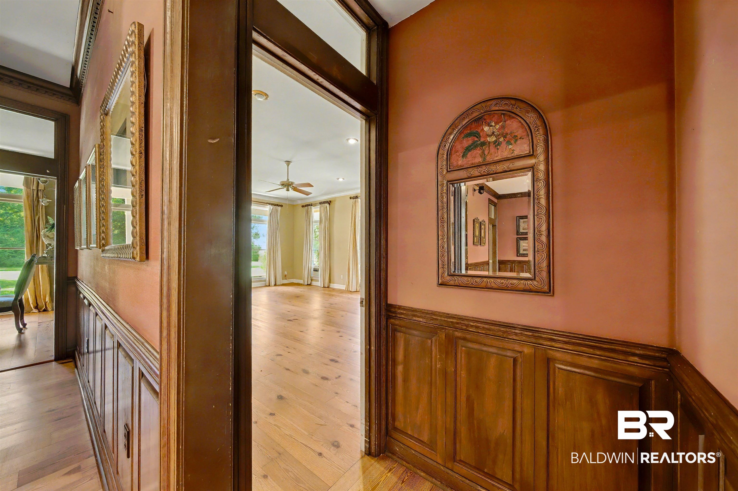 15810 County Road 73 Foley, AL 36535 - Photo 25 of 56 Corridor with a wainscoted wall, light wood finished floors, a decorative wall, healthy amount of natural light, and ornamental molding