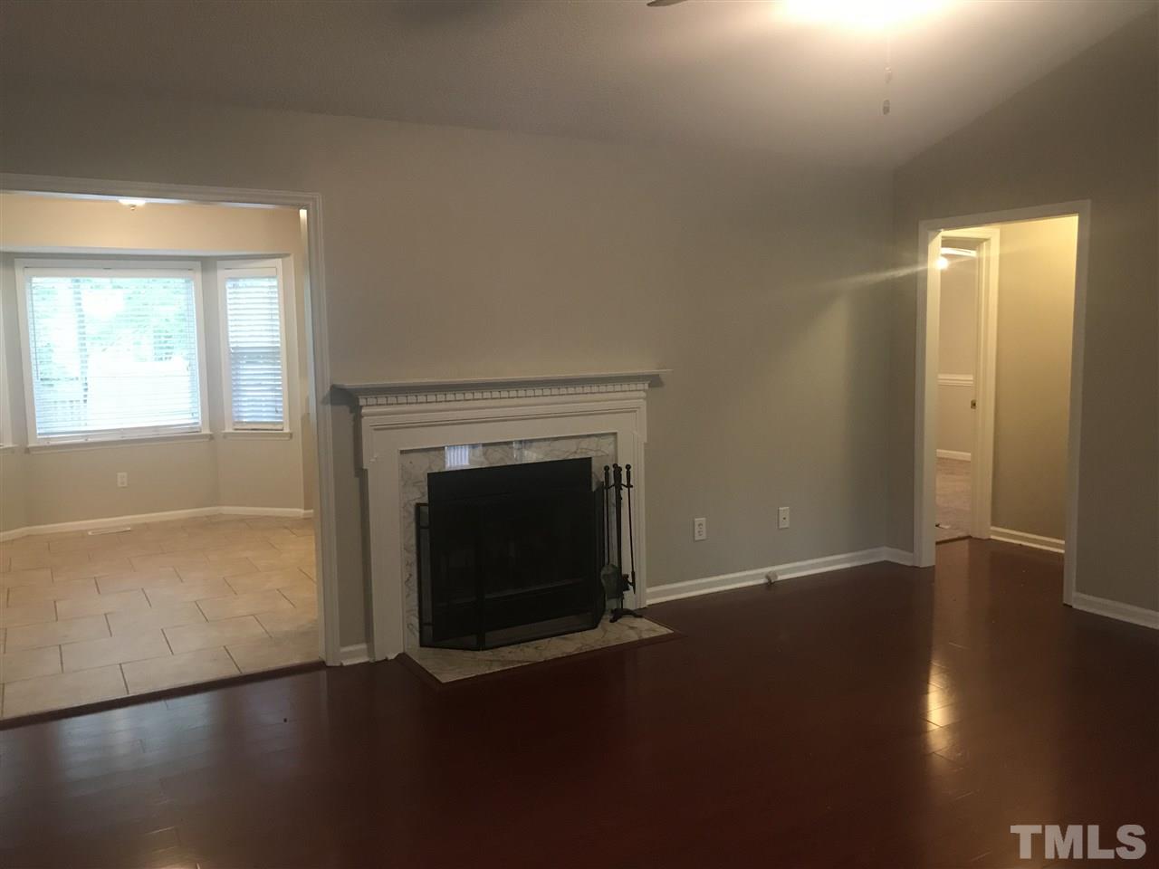 1534 Middle Ridge Drive Willow Spring, NC 27592 - Photo 2 of 23 Spacious Living room with brazilian cherry bambo flooring, wood-burning fireplace and ceiling fan.