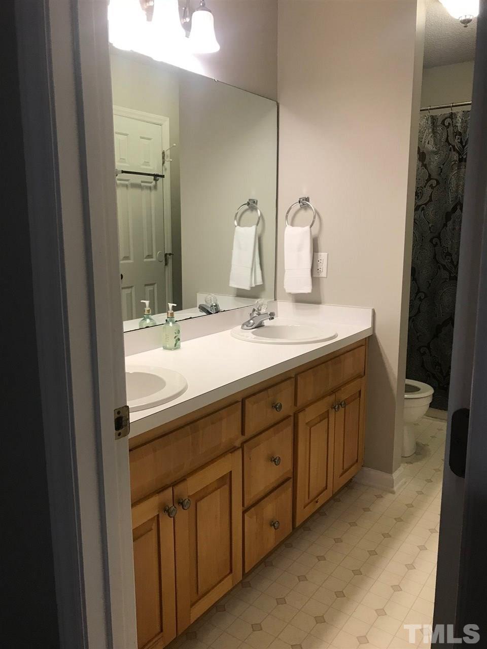 1534 Middle Ridge Drive Willow Spring, NC 27592 - Photo 16 of 23 Master bath with maple cabinet, double vanities and linen closet.