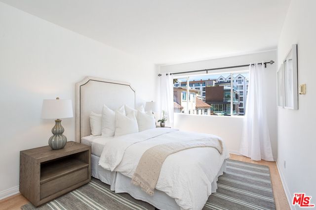 a bedroom with a bed and wooden floor