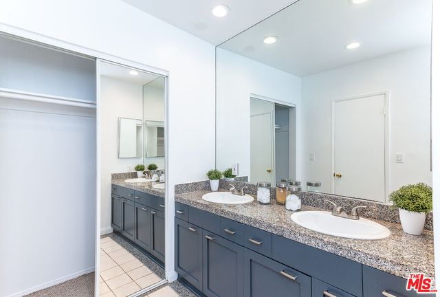 a bathroom with a granite countertop sink double and mirror