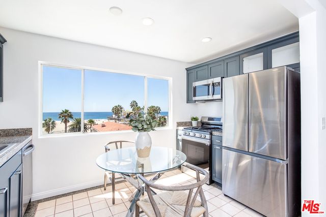 a kitchen with stainless steel appliances a refrigerator and a table