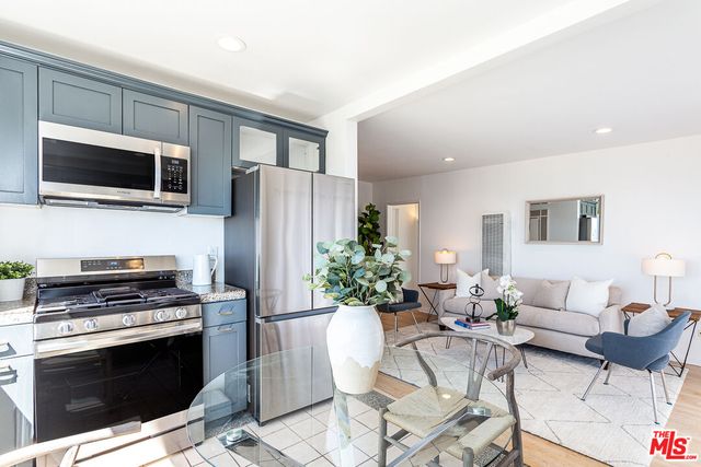 a kitchen with stainless steel appliances a stove a microwave a sink and cabinets