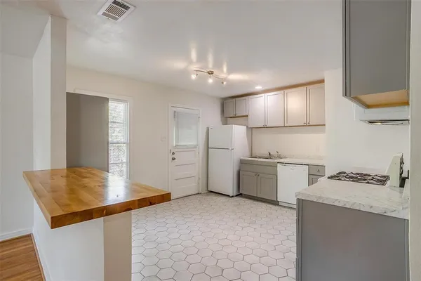 a kitchen with white cabinets and white appliances