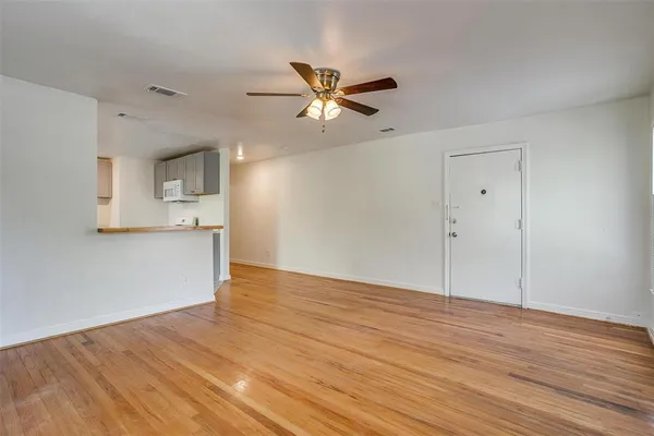 a view of empty room with wooden floor