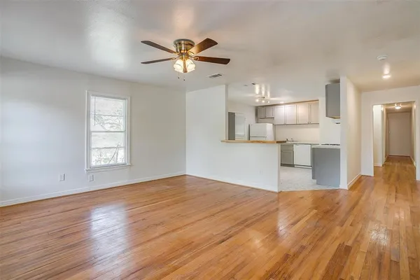 a view of a kitchen with wooden floor and a ceiling fan