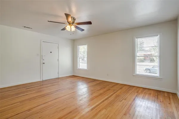 wooden floor in an empty room with a window