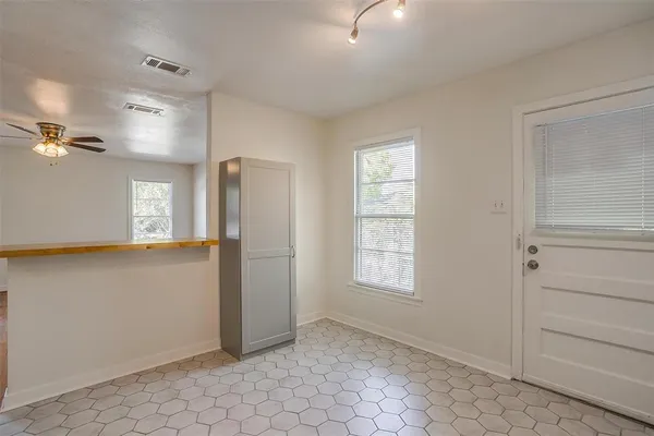 a view of an empty room with window and cabinet