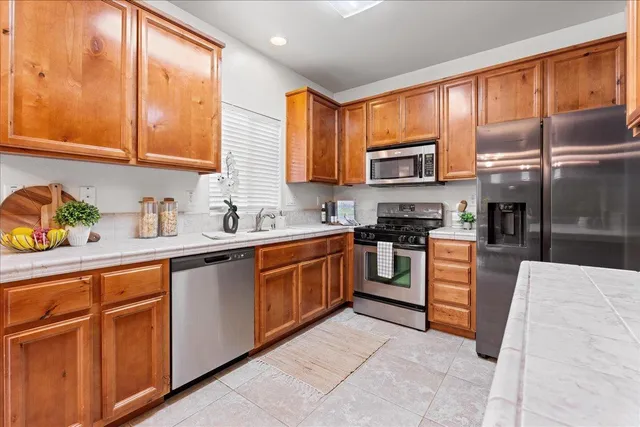 a kitchen with stainless steel appliances granite countertop wooden cabinets a stove top oven a sink and dishwasher