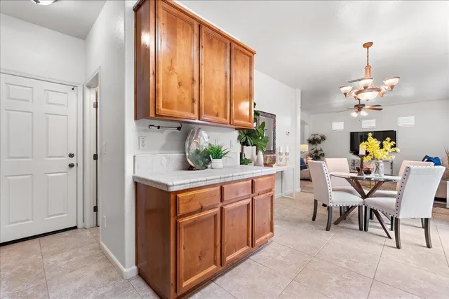a dining hall with stainless steel appliances granite countertop furniture and a kitchen view